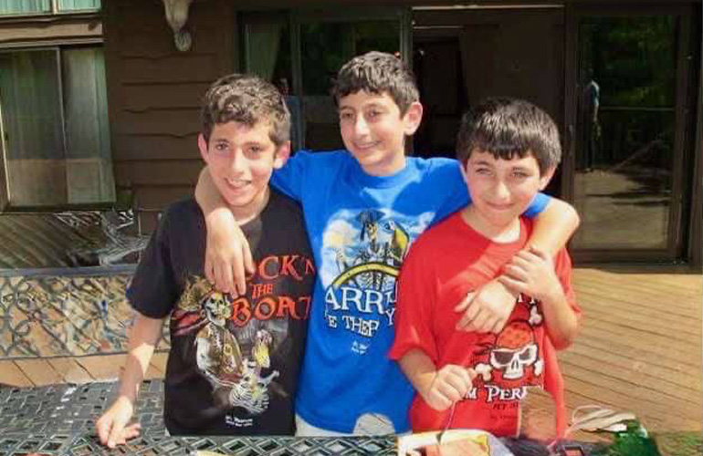 three young boys pose for the camera