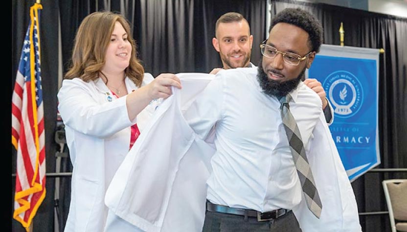A first-year medical student dons his white coat for the first time.