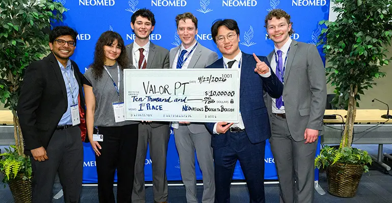 Group of six students from team Valor PT hold a large $10,000 check after winning first place at NEOMED’s Bench to Bedside competition.