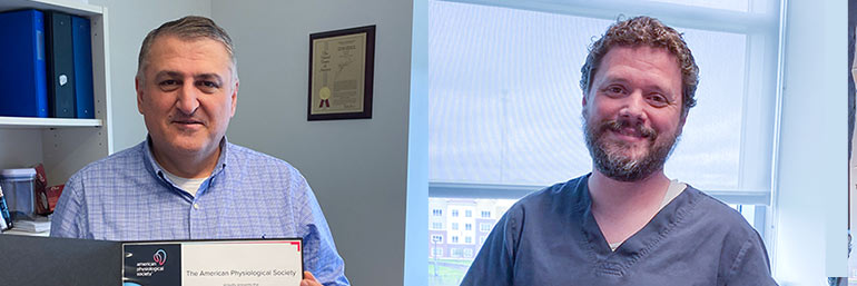 Two scientists are holding certificates announcing their fellowships.