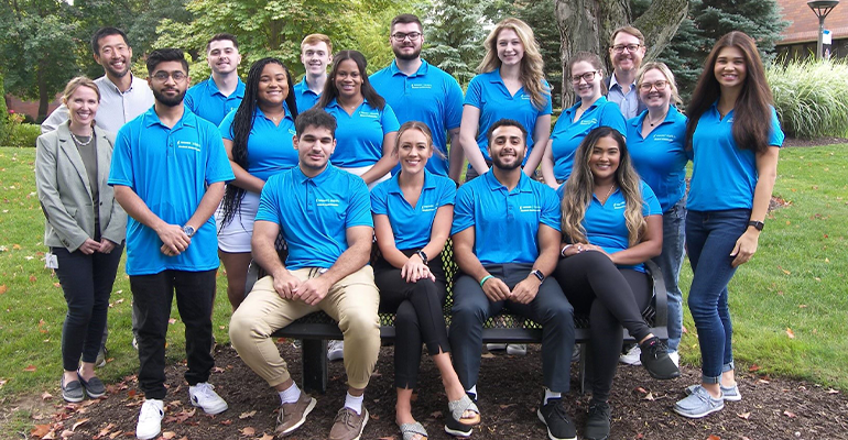 group of college students in matching light blue shirts