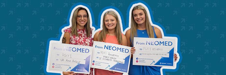 Three pharmacy students hold placards that name their residency sites.