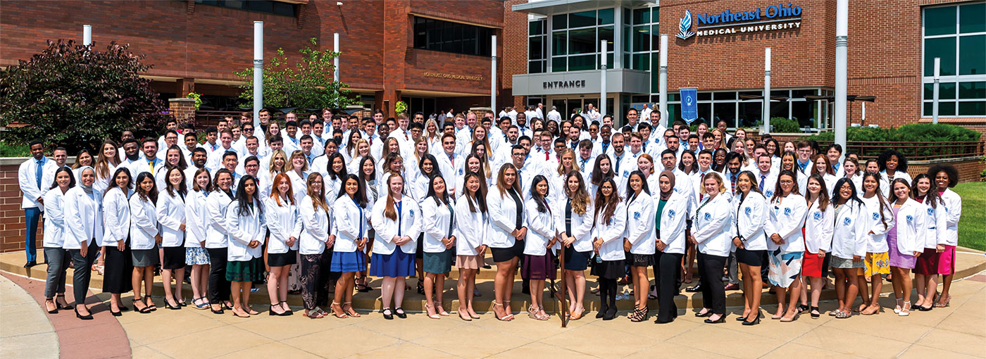 New medical students stand as a group outside as part of NEOMED's White Coat Ceremony.