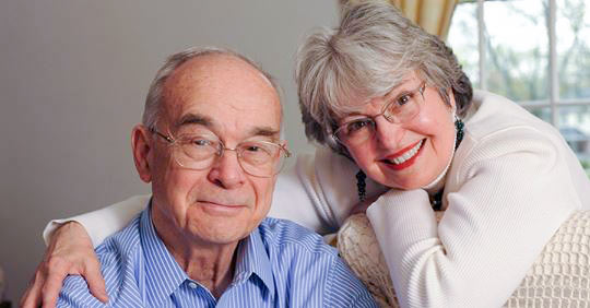 Drs. Fred and Penny Frese sit next to each other in their home.