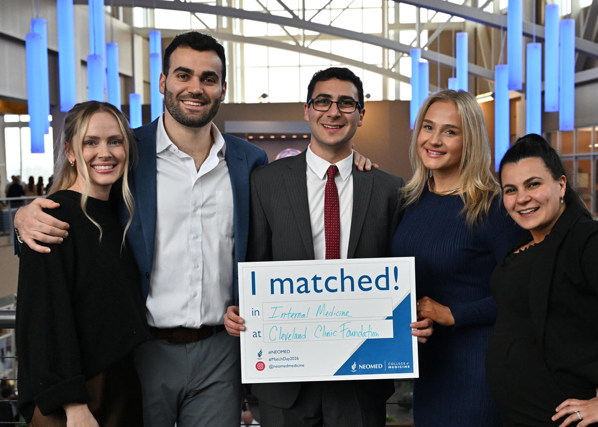 A group of five people stand together, with one holding an “I matched!” sign for internal medicine at Cleveland Clinic, smiling during a Match Day event.
