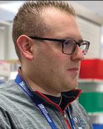 A man wearing glasses looks at a computer screen.