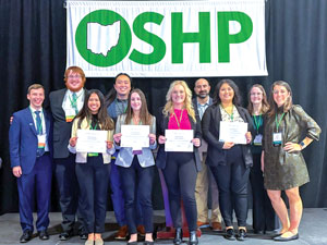 Pharmacy students stand as a group holding certificates they earned in the competition.