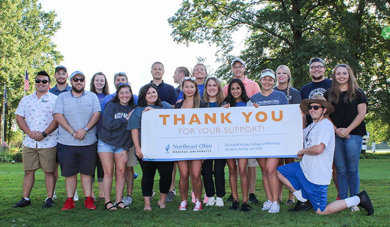 Pharmacy students hold a sign saying Thank You.