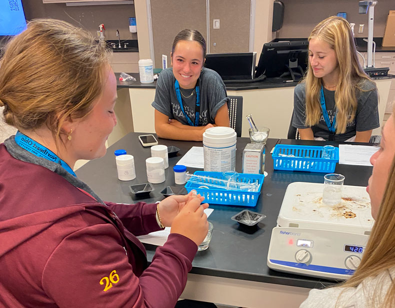 Four women interested in careers in pharmacy work on a lab project during NEOMED's summer pharmacy camp.