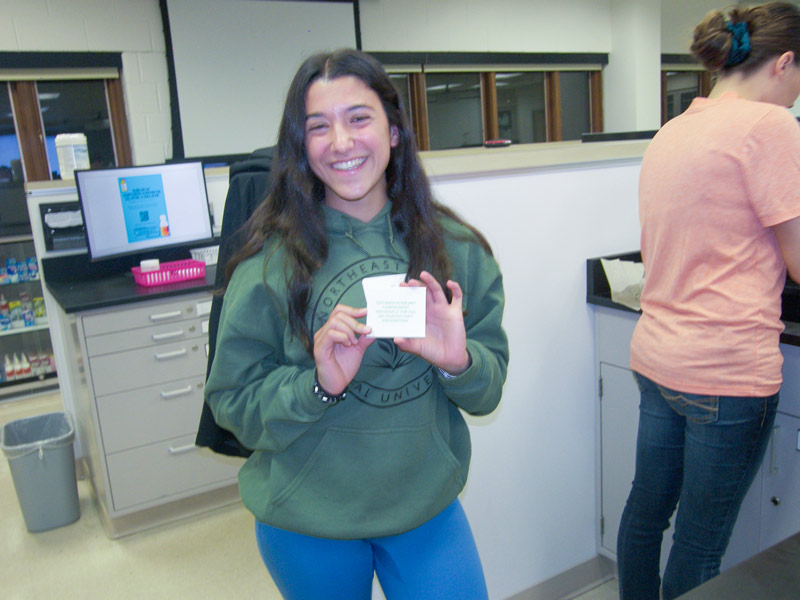 A student holds a card in a NEOMED lab.