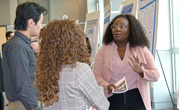 A student presents her research at a poster session.