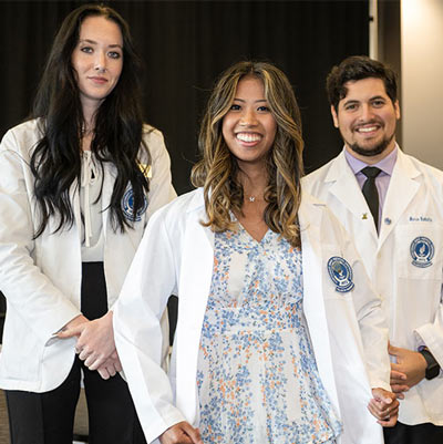 A student beams moments after donning her white coat for the first time.