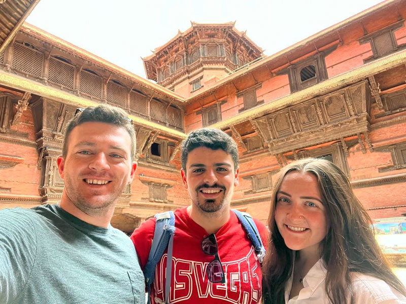 Three medicine students at Kathmandu (Nepal) Durbar Square, inside an old royal palace.