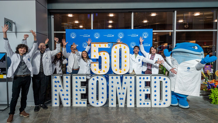 Students surround giant letters that say 50th NEOMED in honor of our anniversary.