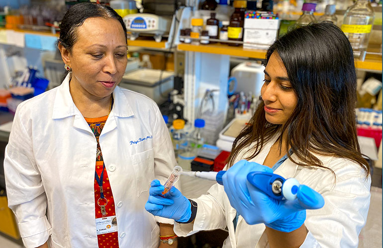 Two researchers in white coats work in NEOMED's REDIzone space in the Greater Cleveland area.