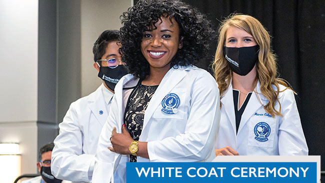 A student dons her white coat for the first time.