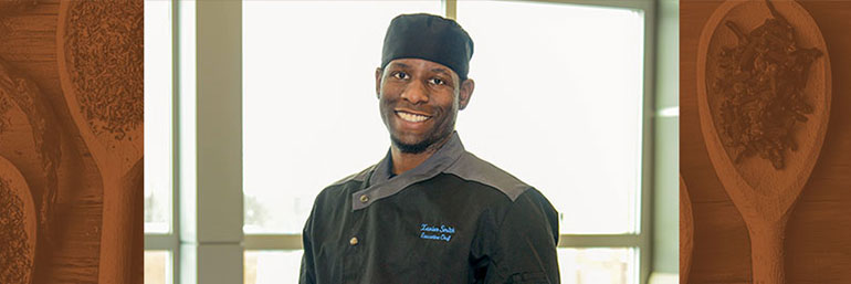 Xavier Smith, the executive chef at the NEW Center, holds a tray of foods.